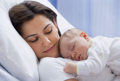 New mom_baby_breast feeding tips_baby care photolibrary_rf_photo_of_mom_napping_with_newborn,breast, feeding, new moms, tips