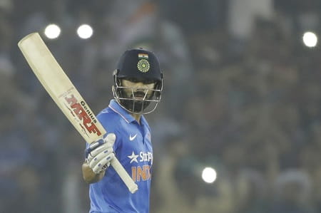 India's Virat Kohli raises his bat after scoring a century during their third one-day international cricket match against New Zealand in Mohali, India, Sunday, Oct. 23, 2016. (AP Photo/Tsering Topgyal)